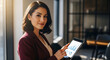 © Divya - Professional young businesswoman analyzing data on digital tablet in a modern office