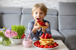 © Tomsickova - Sweet preschool child, boy, eating belgian waffle with strawberries and chocolate at home