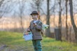 © Tomsickova - Beautiful stylish toddler child, boy, playing with Easter decoration in the park, springtime