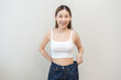 © KMPZZZ - Shape slender, thin waist, slim fit asian young woman, showing body shape her weight loss, happy wearing in big, large or oversize jeans, excess lose by diet and exercise. Healthy lifestyle concept