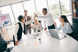 © deagreez - Professional team celebrating success with a high-five in a modern office setting promoting collaboration and teamwork