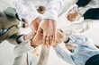 © deagreez - Diverse team unites hands together in collaborative teamwork, fostering trust and connection in a professional workplace environment