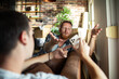 © Davor - Two men discussing moving plans on smartphone at home