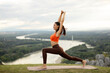 © Home-stock - Young lady practicing yoga against city view on top of mountain, spending morning for active workout outdoors, free space