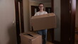 © Aliaksandr - Woman carefully carrying a packed cardboard box, actively transporting personal belongings during a household move, symbolizing new beginnings and the process of relocation