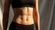 © Tatiana - Person Stands in Front of a Light Backdrop Showing a Fit Torso and Midsection During a Fitness Session in a Studio on a Bright Day