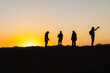 © StockMediaSeller - Silhouettes of travelers taking photo at desert sunset in Egypt with mountains on horizon