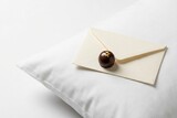 Luxury chocolate truffle and envelope on white hotel pillow