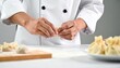 © ruangrit19 - Chef preparing dumplings professionally in a well lit kitchen showcasing culinary craftsmanship and expertise.
