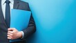© Johannes - sales executive holding sales report folder on a blue business background ar 169