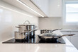 © Meow Creations - Stainless steel pots and pans on modern kitchen induction stove