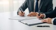 © Your Stock Studio - Two businessmen signing important legal documents and contracts at office desk with pens and papers, demonstrating professional teamwork and collaboration.