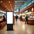 © Viktor - Blank digital advertisement screen stands in busy food court with people walking past shops and cafes. Modern interior space for retail marketing promotion.