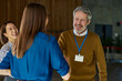 © bernardbodo - Diverse business people greeting and smiling during a friendly conference meeting and networking handshake