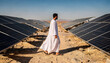 © Oleksandr - Middle Eastern male in white attire walks between rows of solar panels in a sun-drenched desert landscape, symbolizing renewable energy and progress