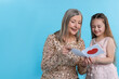 © New Africa - Little girl greeting her grandmother with holiday card on light blue background, space for text