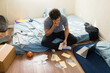 © AntonioDiaz - College student counting money at home, managing personal finances with stress in his first independent apartment