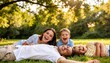 © Oudin_store - Happy Family of Four Laughing and Laying on Green Grass