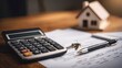 © emi  raina - Calculator, house model, keys, and documents on wooden table for home financing and mortgage planning