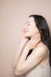 © kapinon - 黒髪が綺麗でベージュ背景の若い女性の艶や透明感のあるビューティーイメージ　横顔で見上げる