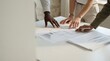 © Tonton1541 - mortgage property terms value paperwork concept. Team examining architectural plans on a table