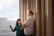 © Johnér - Senior businesswoman gesturing while explaining strategies to male coworker standing near window in office