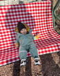 © phpetrunina14 - Smiling toddler in winter snowsuit on red checkered blanket Portrait