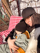 © phpetrunina14 - Mother cuddling toddler outdoors in winter sunlight.