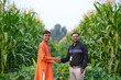 © PRASANNAPIX - young indian agronomist or banker and farmer standing together at green corn field