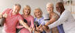 © Prostock-studio - Five seniors stand in a studio holding yoga mats and smiling. They show thumbs up sign and are ready for their class. A bright atmosphere suggests a joyful meeting.