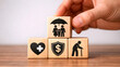 © Ripon - 'A businessman demonstrates financial and insurance planning with wooden blocks on coins, symbolizing retirement, family coverage, healthcare, and money protection—highlighting strategies for wealth s