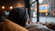 © Thares2020 - Person in a grey beanie resting on a leather couch observing a blurred urban street scene