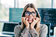 © deagreez - Stressed female programmer biting her nails while debugging complex code on multiple monitors in a modern open office, showing anxiety and deadline pressure