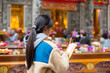 © leungchopan - Woman praying inside temple holding incense stick