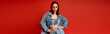© Bliss - Stylish young woman poses confidently in denim outfit against a bold backdrop
