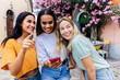© Xavier Lorenzo - Multiracial young female friends looking at smartphone outdoors. Happy women sharing digital moments while exploring a city together. Technology and friendship concept.