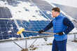 © Serhii - Worker cleaning snow from solar panels in winter
