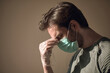 © Teodor Lazarev - Man wearing disposable mask and plastic glove, experiencing stress and headache, covering his face with his hand feeling tired from mental pressure during the pandemic