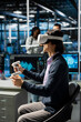 © DC Studio - Developer wearing VR headset coding in data center, updating AI automation scripts. Server room employee using virtual reality, programming artificial intelligence algorithms