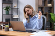 © New Africa - Woman feeling fatigue at wooden desk in office
