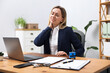 © New Africa - Woman feeling fatigue at wooden desk in office