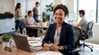 © Isaque Taylor - Smiling African American Businesswoman Working in a Modern Open-Plan Office