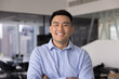 © fizkes - Confident young Asian businessman posing for headshot portrait in corporate office enjoying successful work achievements or creating professional profile picture for social media and career platforms
