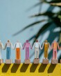 © Ryzhkov - Diverse Wooden Figures Holding Hands in a Row Representing Community and Teamwork Standing on a Yellow Ledge with Plant Shadows and Copy Space Background