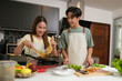 © Success Media - Asian Young couple cooking in the kitchen at home