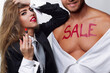 © Volodymyr - Sale luxury fashion couple in studio portrait. Sale painted body message for marketing concept. Sale promotion advertising with glamour style. Sale campaign symbol for retail commerce.