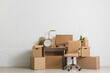 © Pixel-Shot - Office desk with chair and moving boxes near white brick wall