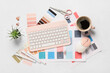 © Pixel-Shot - Computer keyboard with mouse, cup of coffee, stationery and color palettes on white background, top view