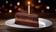 © Antonio - chocolate cake with single candle illuminating delicious slice