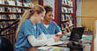 © peopleimages.com - Girl, medical student and friends with laptop at library for research, writing and brainstorming at campus. People, healthcare scholarship and computer with books, discussion and notes at university
